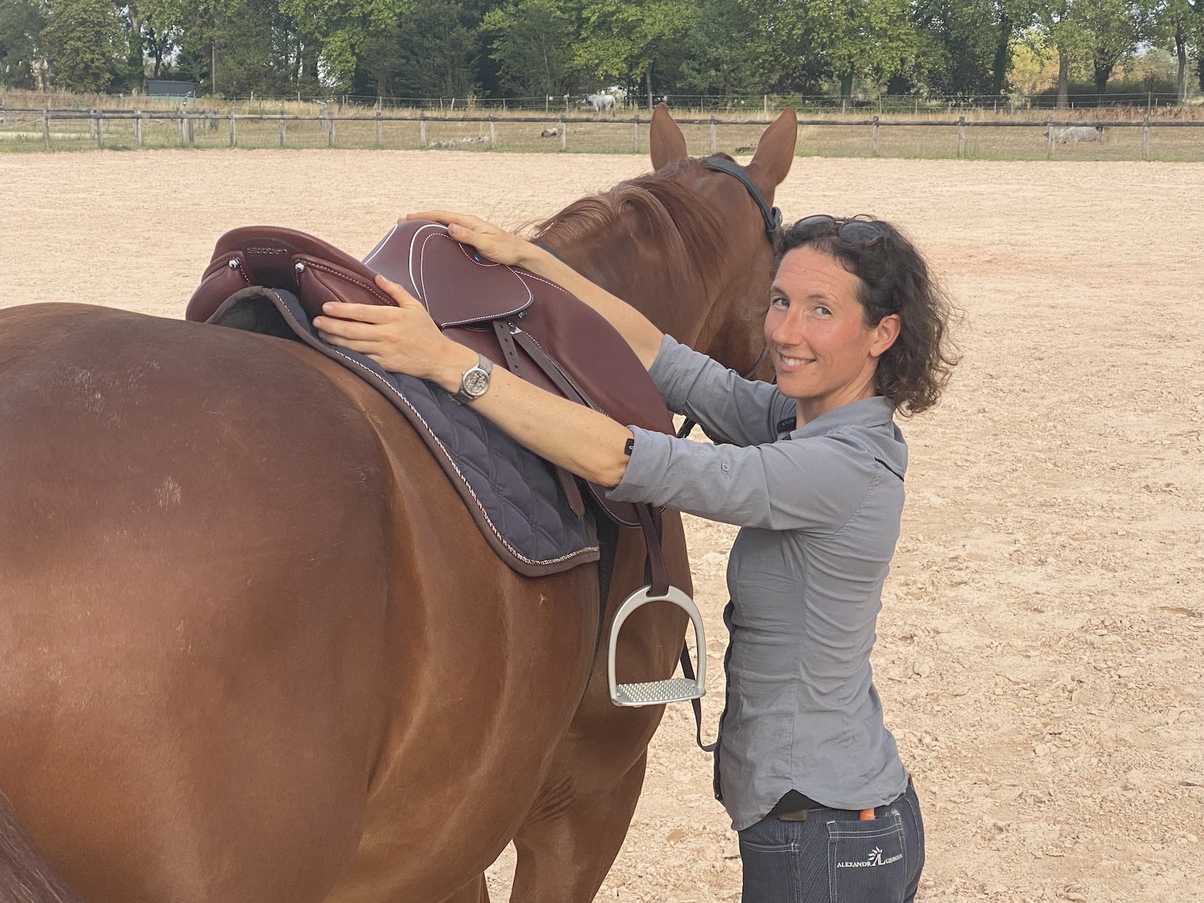 Une femme sellant un cheval