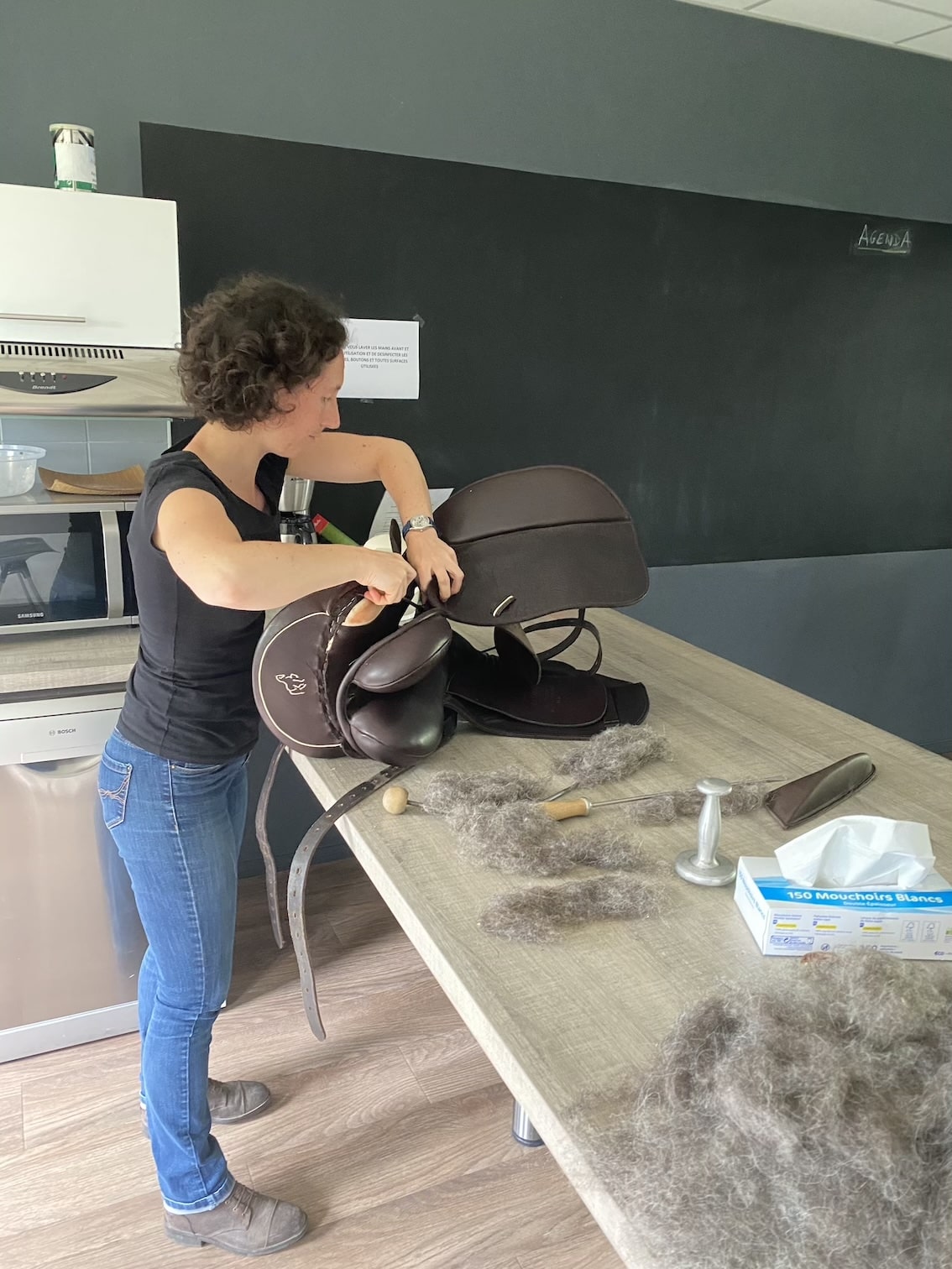 Une femme répare une selle